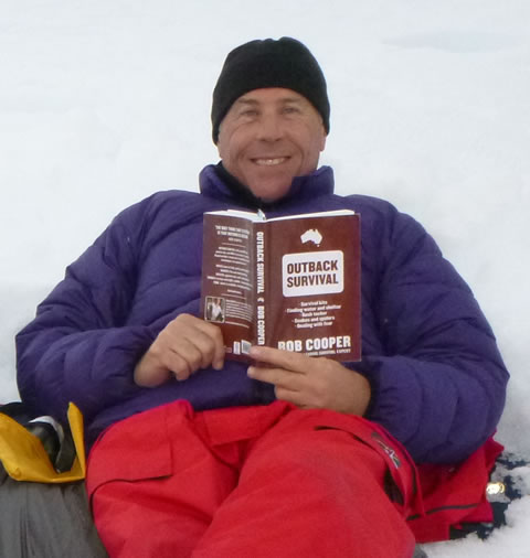 Chris Pervan in Antarctica with his copy of Outback Survival
